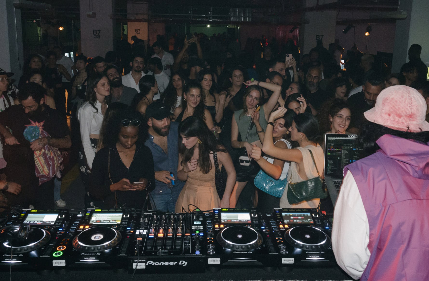 Crowd dancing in front of a DJ booth at an event at ICD Brookfield Place